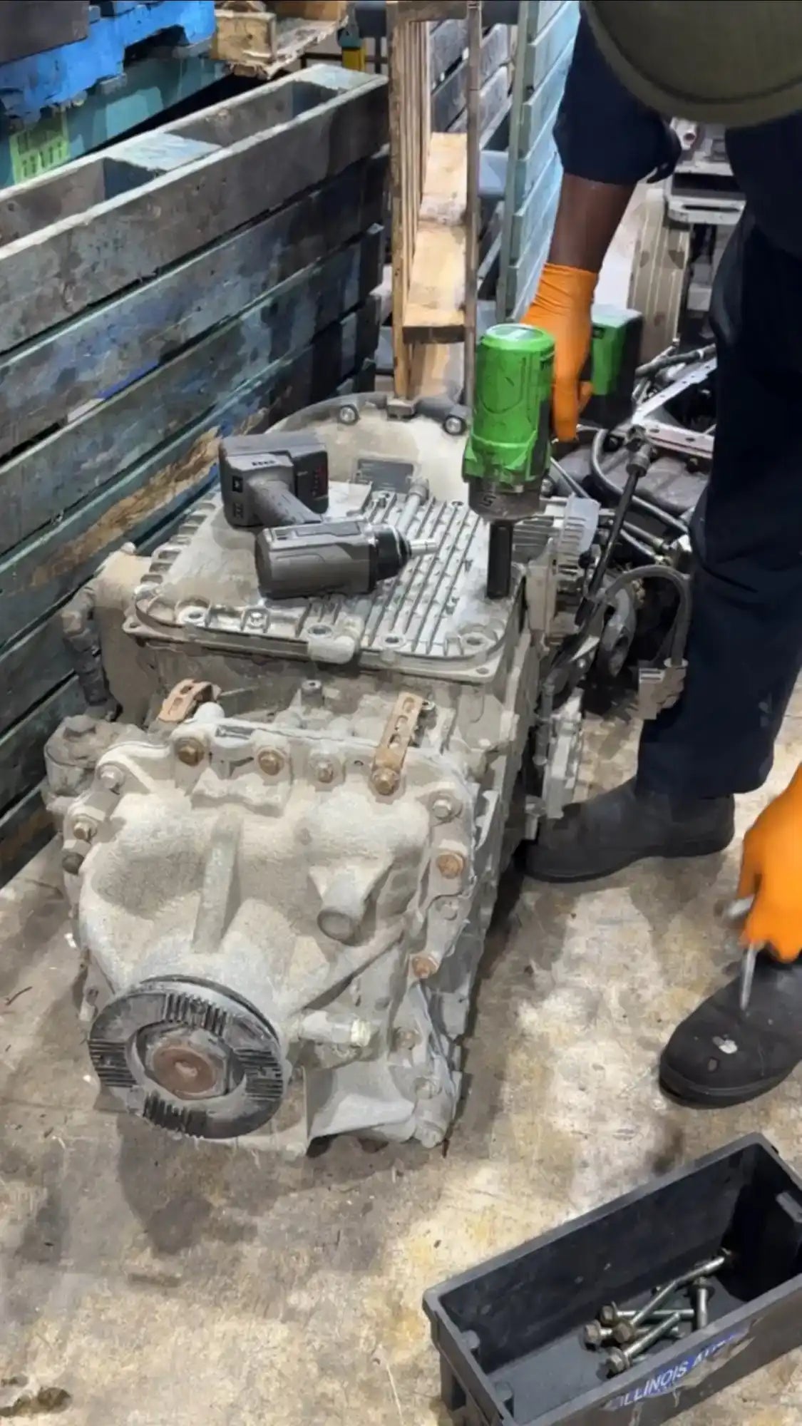 A large, complex metal mechanical assembly, possibly an engine or transmission, with various components and fasteners.